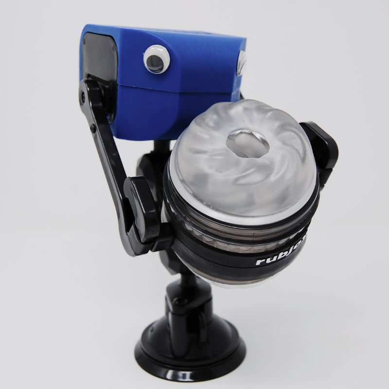 Rubjoy robotic pleasure machine with googly eyes showing dual-servo arm holding included sleeve on adjustable stand
